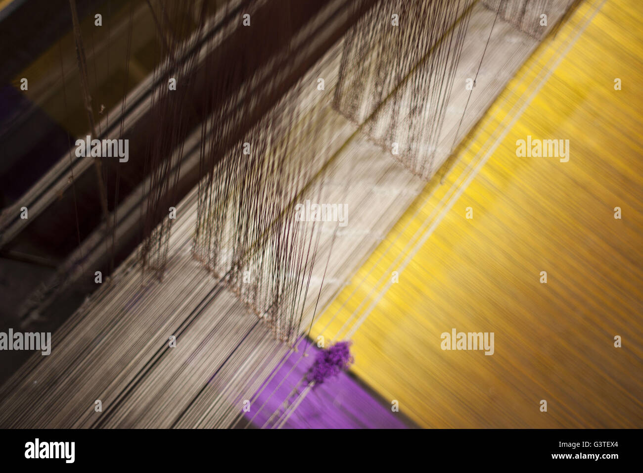 June 15, 2016 - Dhaka, Bangladesh - Colored silk threads on a handloom for making Banarasi sareesi at Mirpur Banarasi Palli, in Dhaka, Bangladesh. Business in Mirpur Banarasi Palli, a market place well-known for different kinds of traditional Banarasi Sarees in Bangladesh, is facing tough times. People, who used to go there to purchase the famous Banarasi sarees, are increasingly opting for trendy Indian sarees. The popularity of these custom-made sarees is losing its charm as colorful Indian chic sarees are more in demand among local buyers. The Benarasi saree, whose history dates back to the Stock Photo