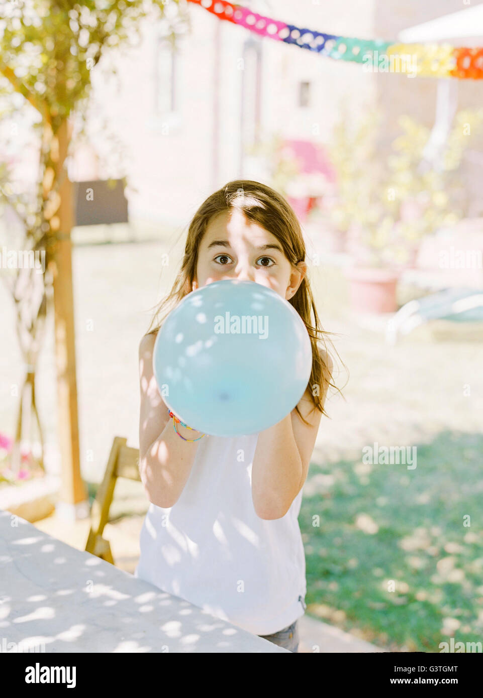 Italy, Boy (8-9) inflating blue balloon Stock Photo