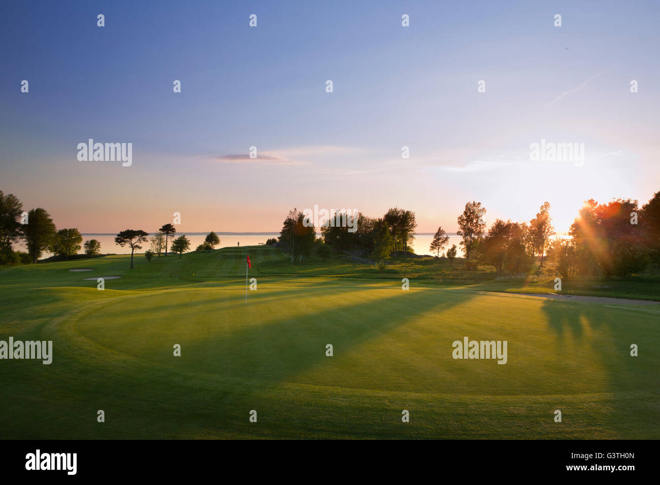 Sweden, Ostergotland, View of Ombergs Golf Resort by Lake Vattern at sunset Stock Photo