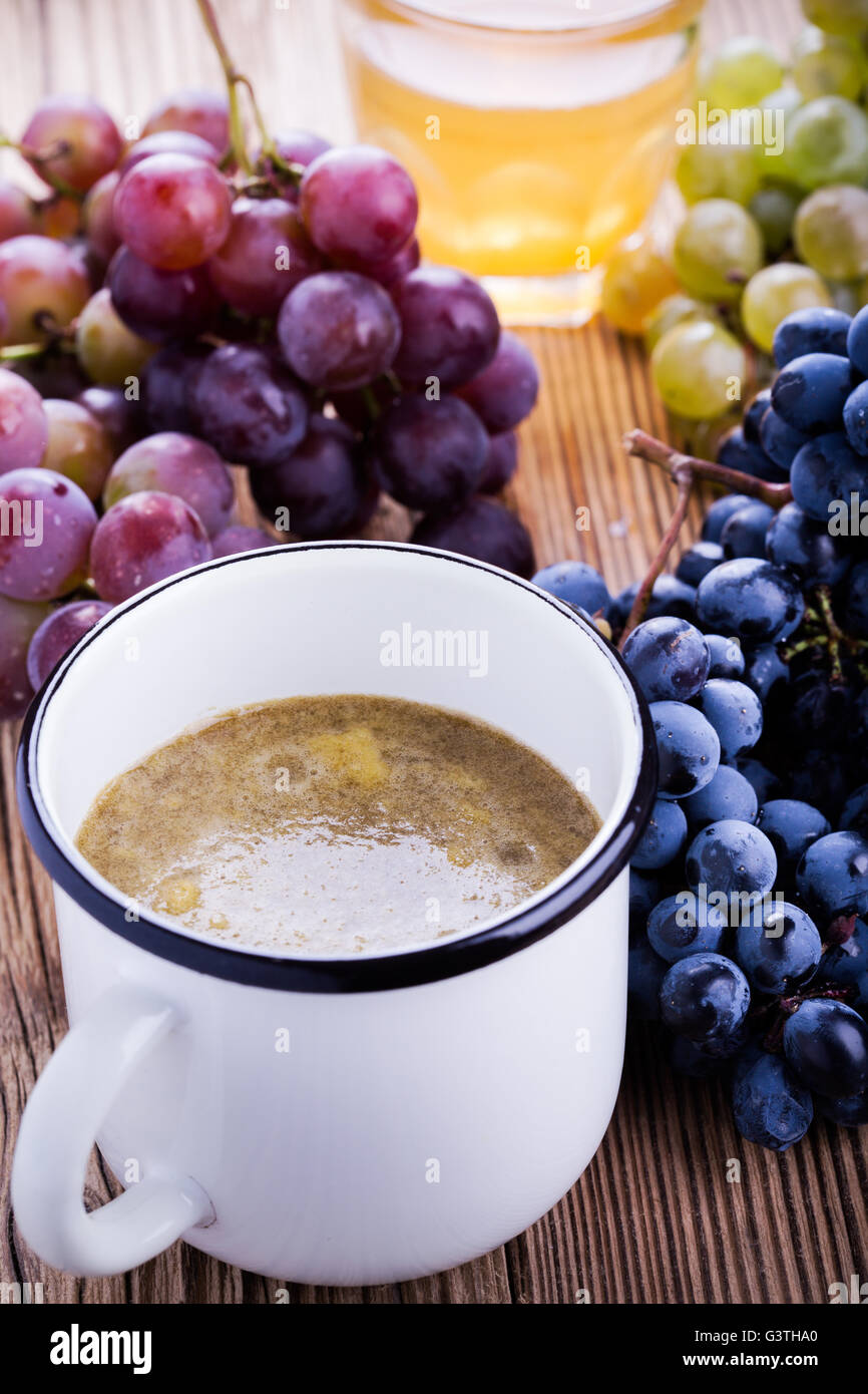 Fresh black, red and green grapes and freshly squeezed grape juice on
