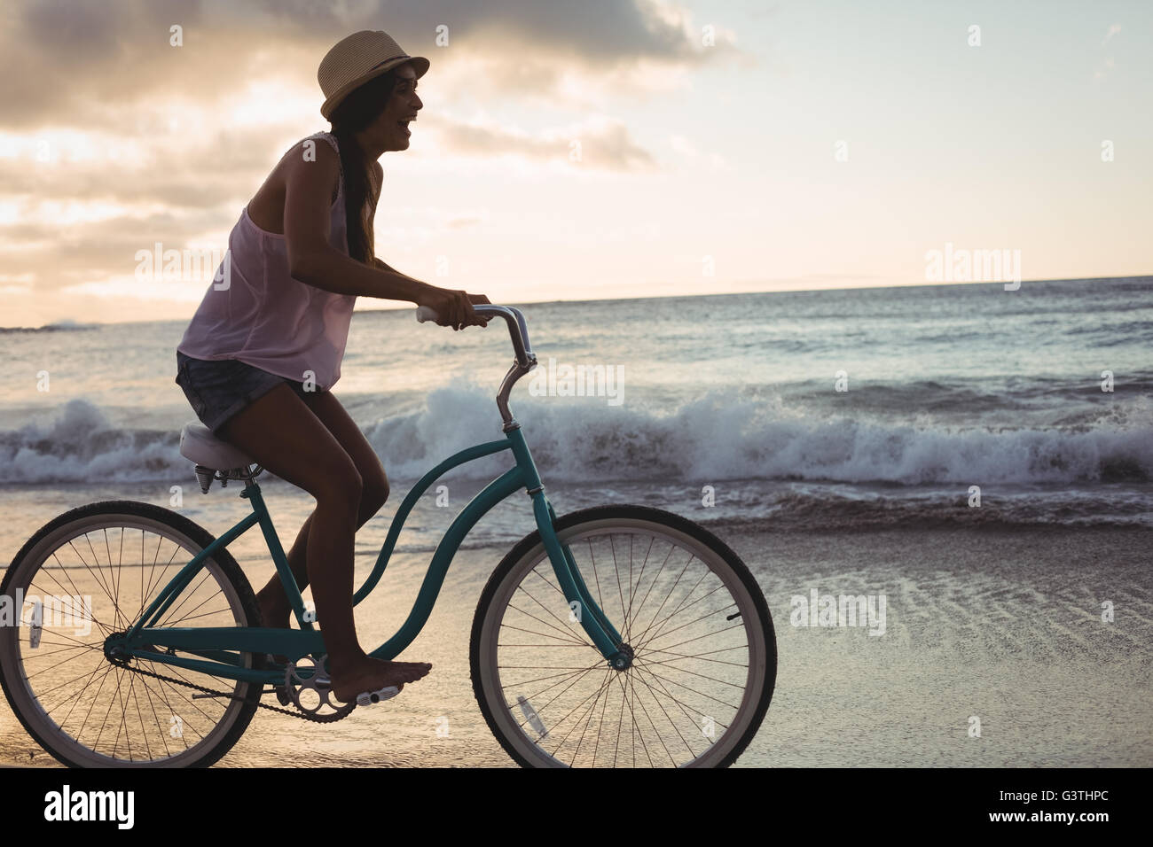 Woman cycling on the beach Stock Photo