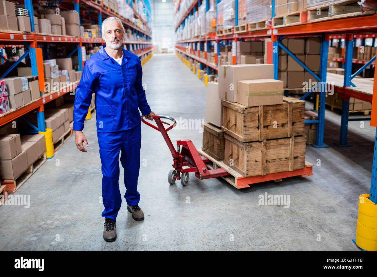 Portrait of man worker pulling the pallet truck Stock Photo