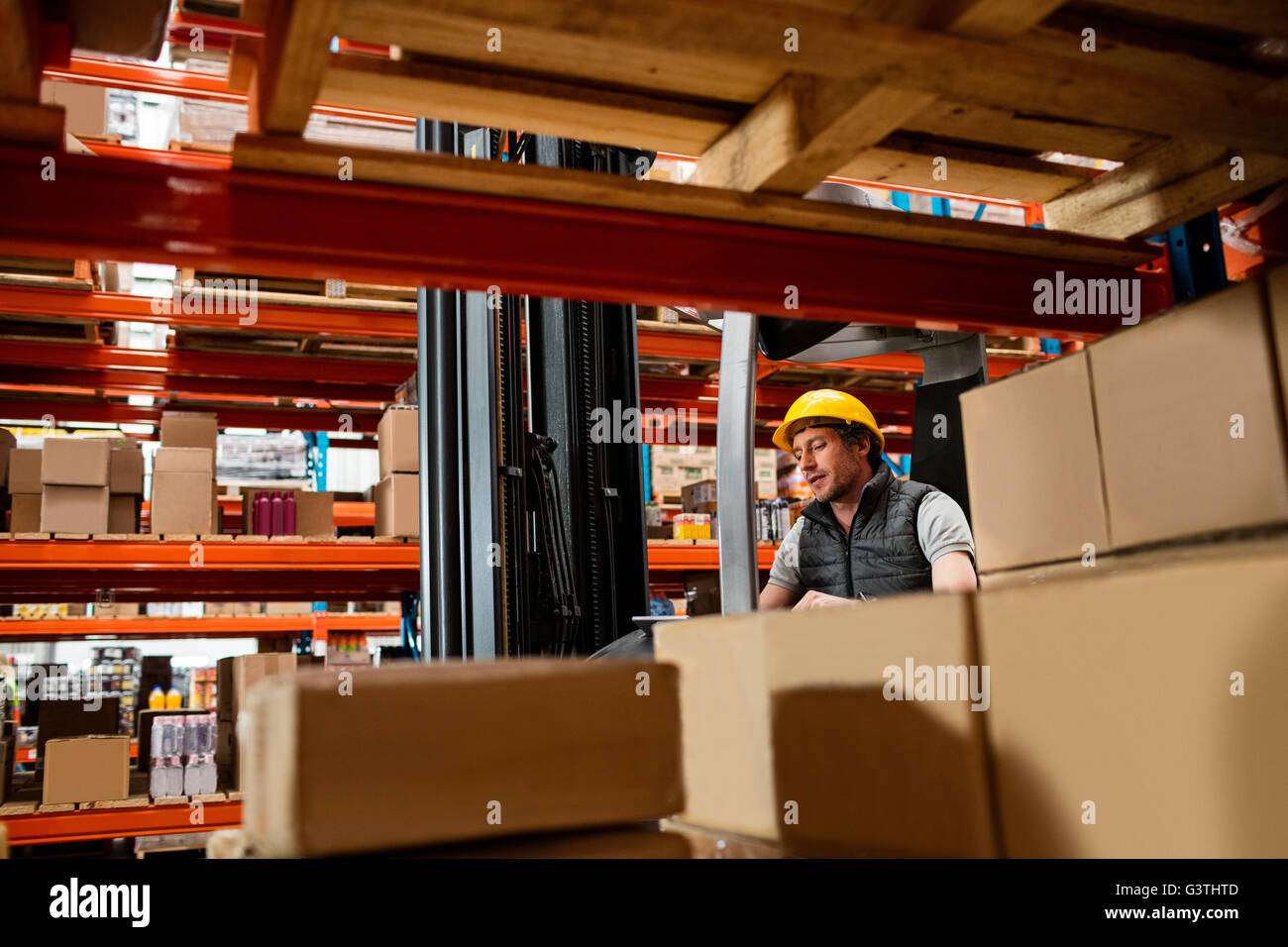 Warehouse worker driving forklift Stock Photo Alamy