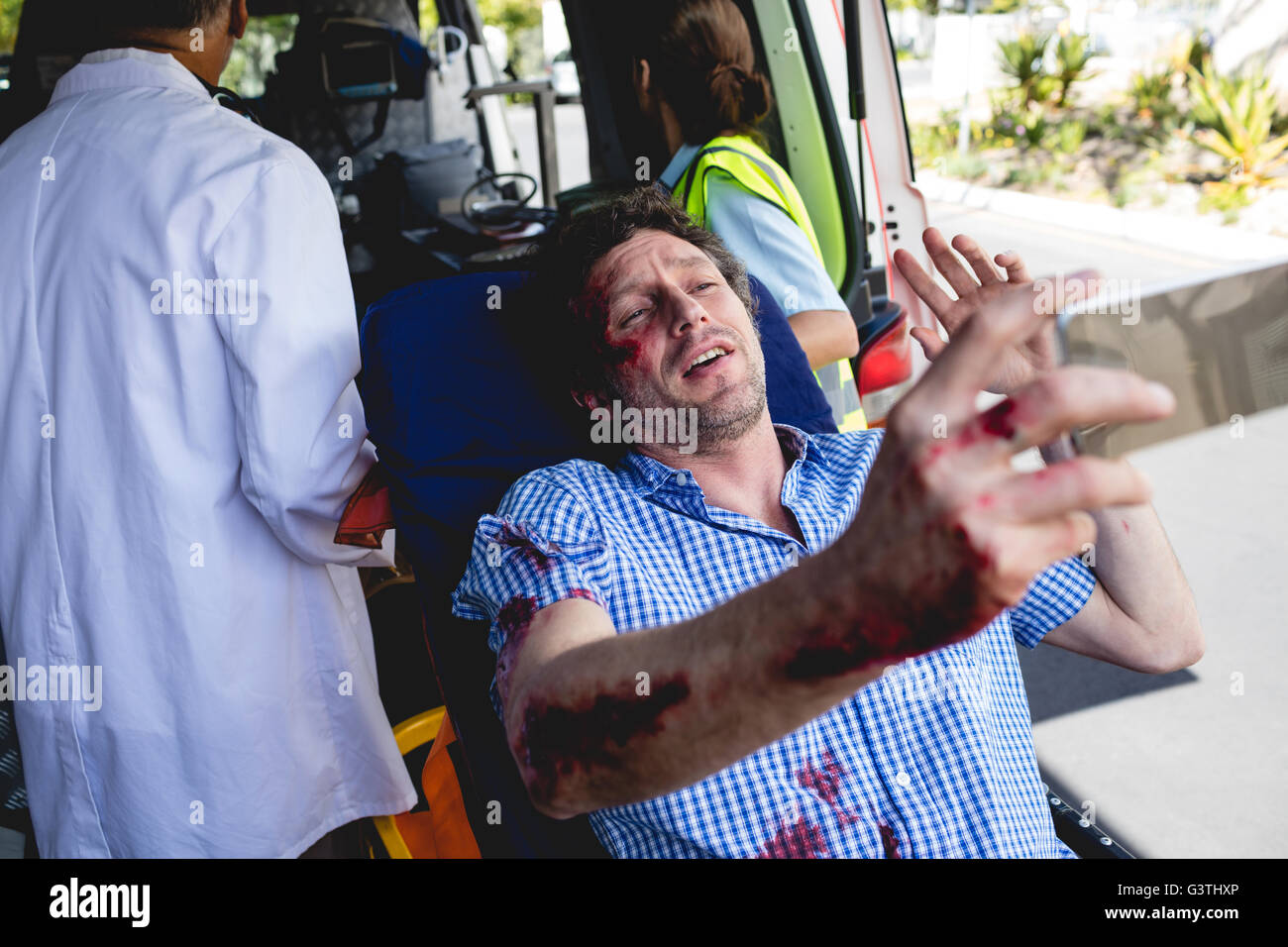 Injured man with ambulance men Stock Photo