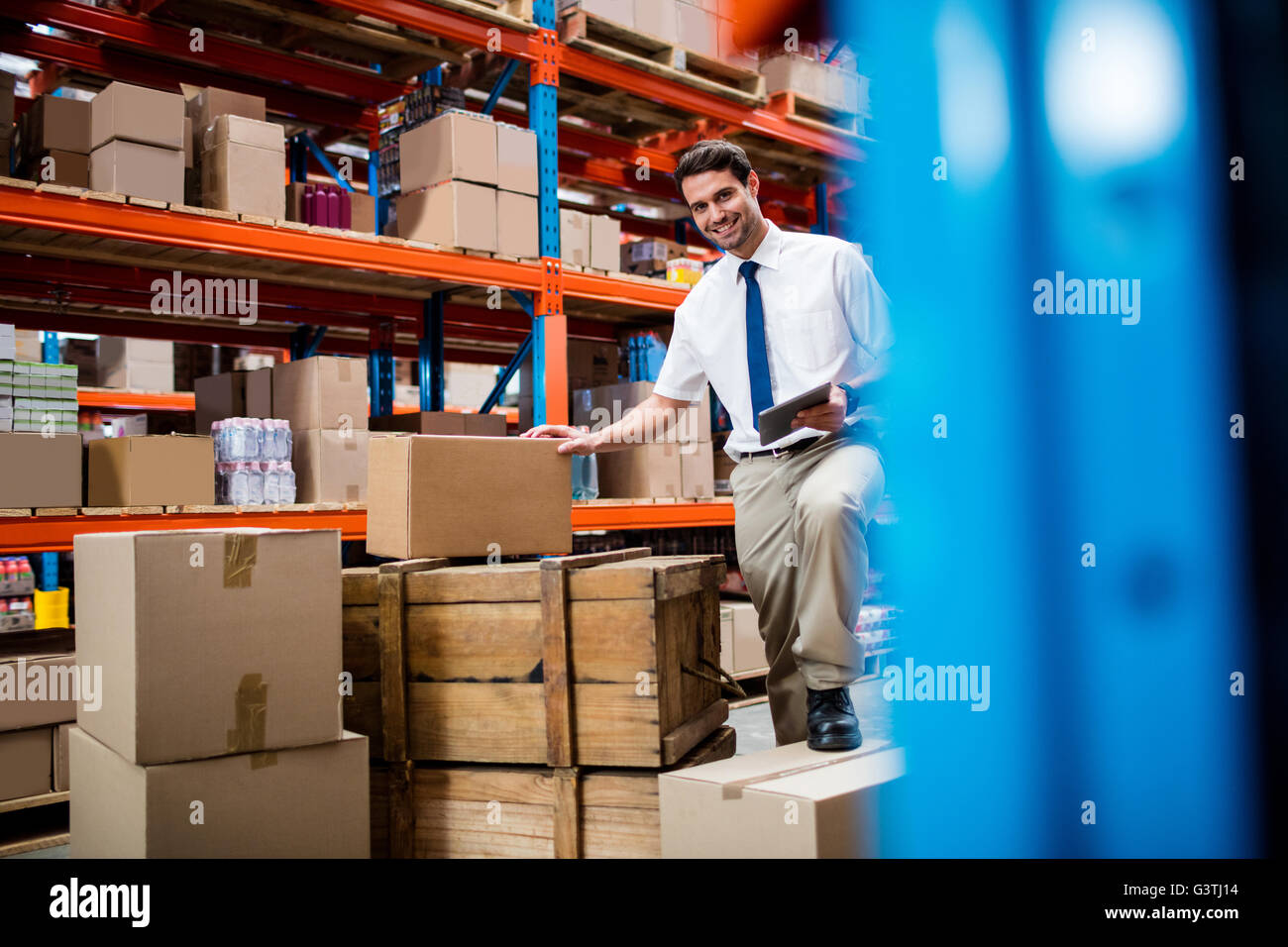 Warehouse manager with boxes and clipboard Stock Photo