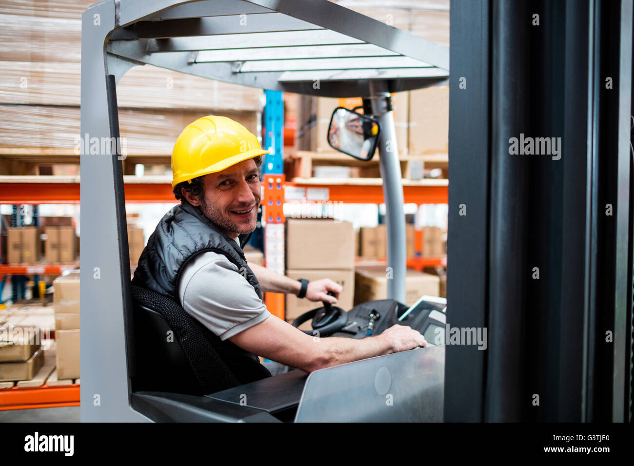 Warehouse worker driving forklift Stock Photo Alamy
