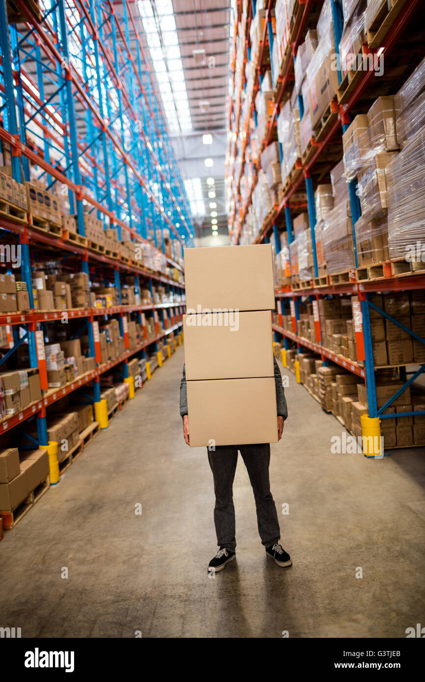Obscured worker carrying boxes Stock Photo