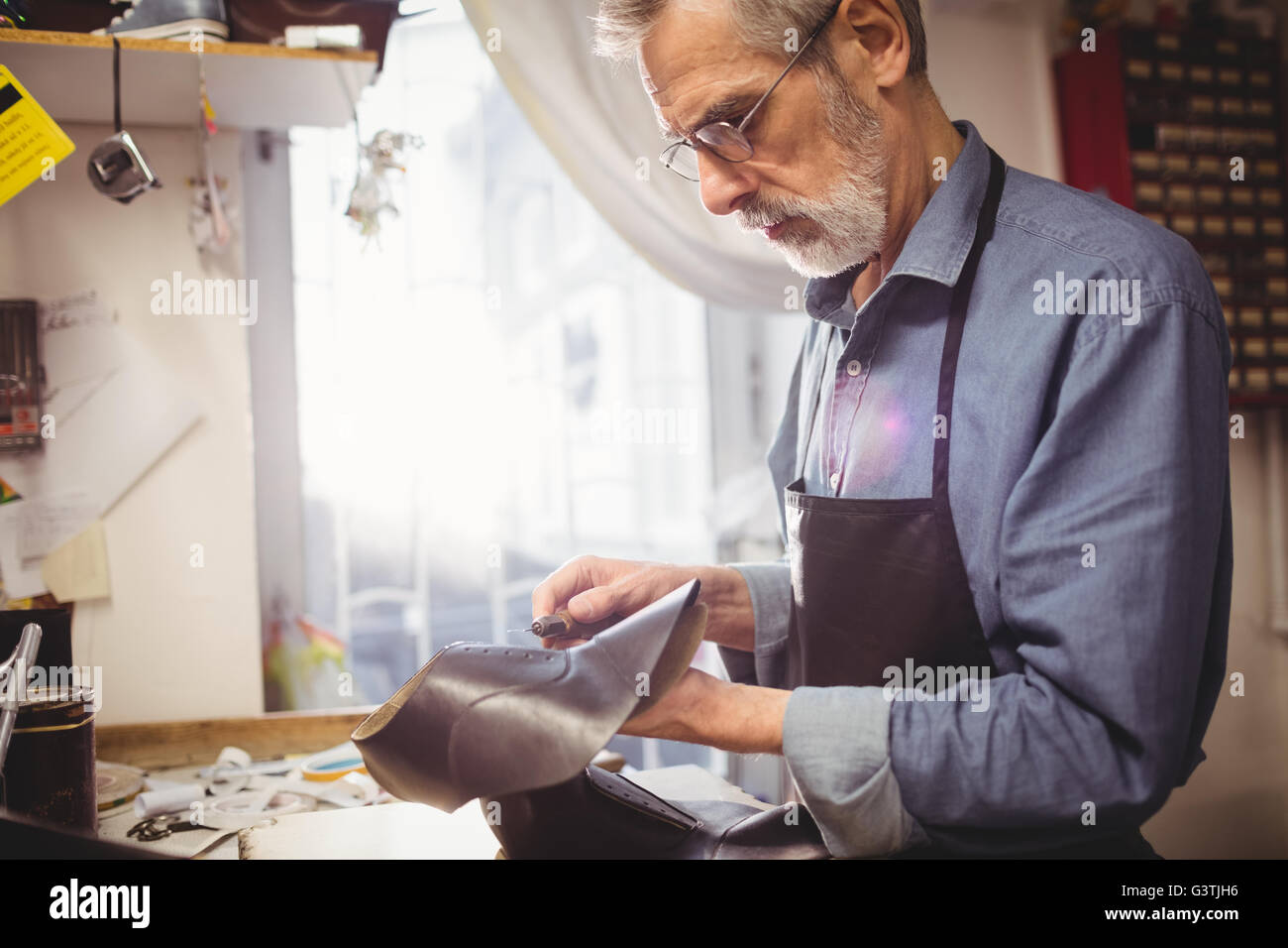 Profile view of cobbler making a shoe Stock Photo