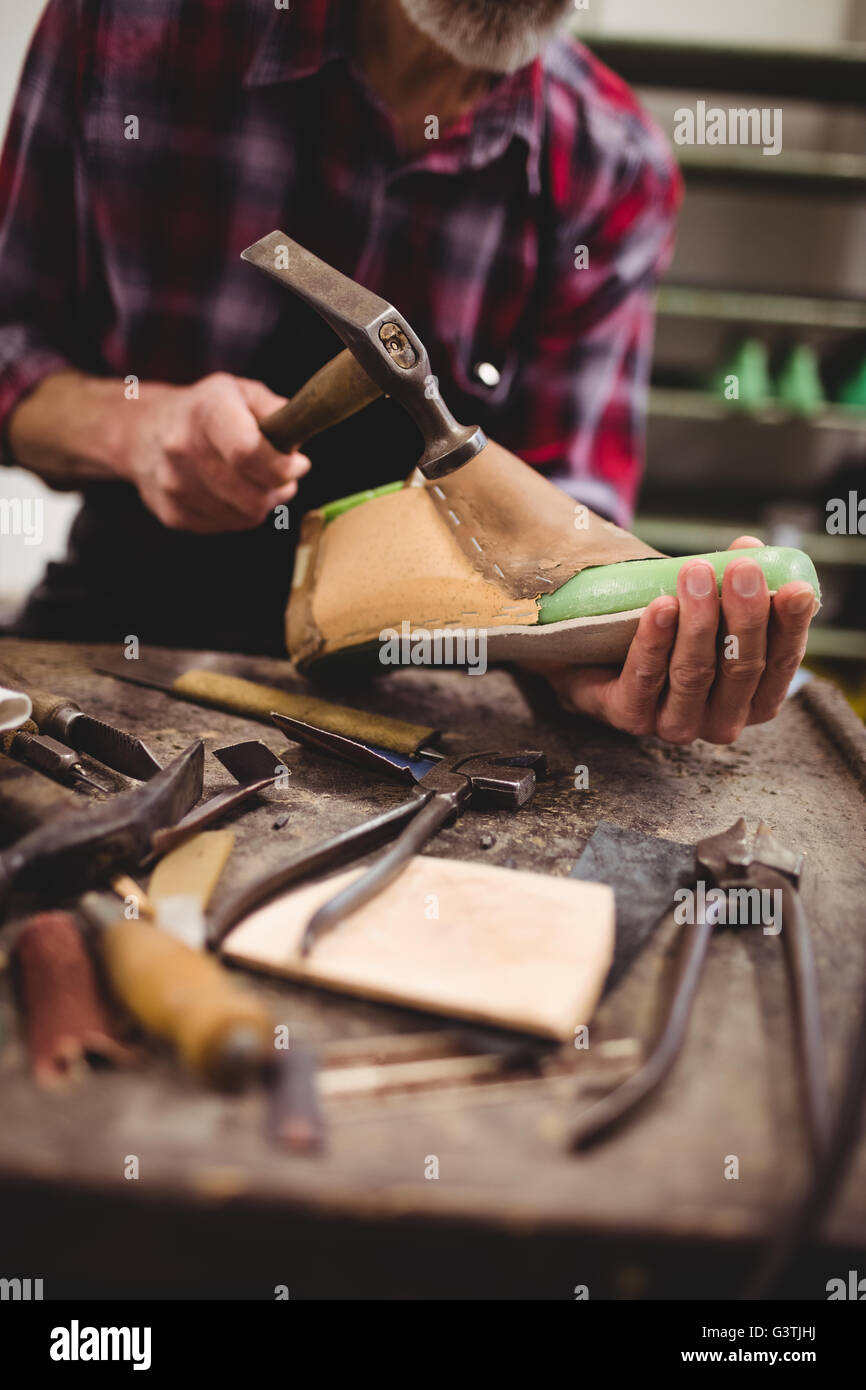 Cobbler hammering on a shoe Stock Photo