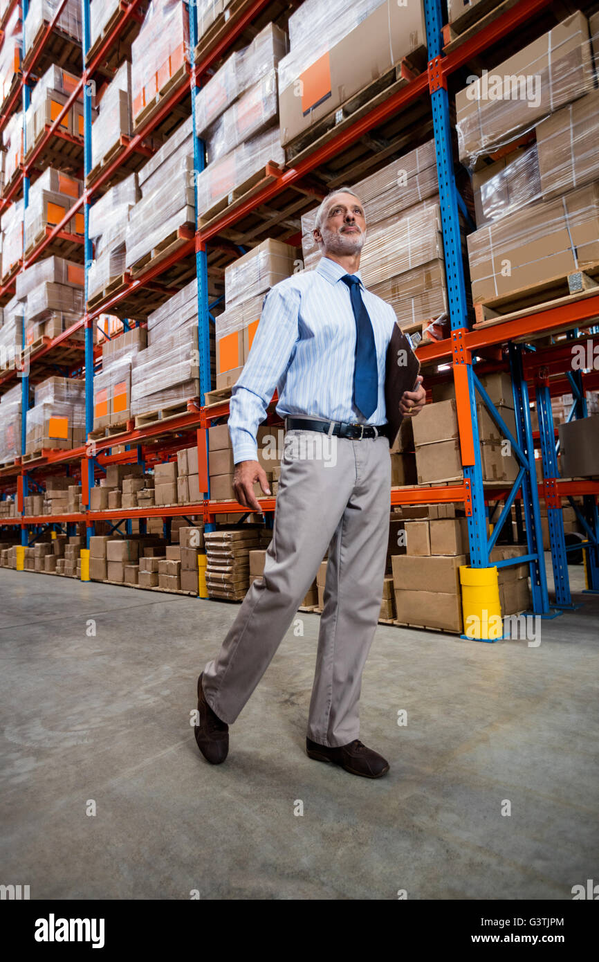 Warehouse manager walking in the aisle Stock Photo