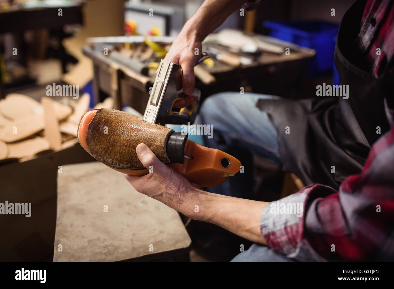 Close up of hands stapling a shoe Stock Photo