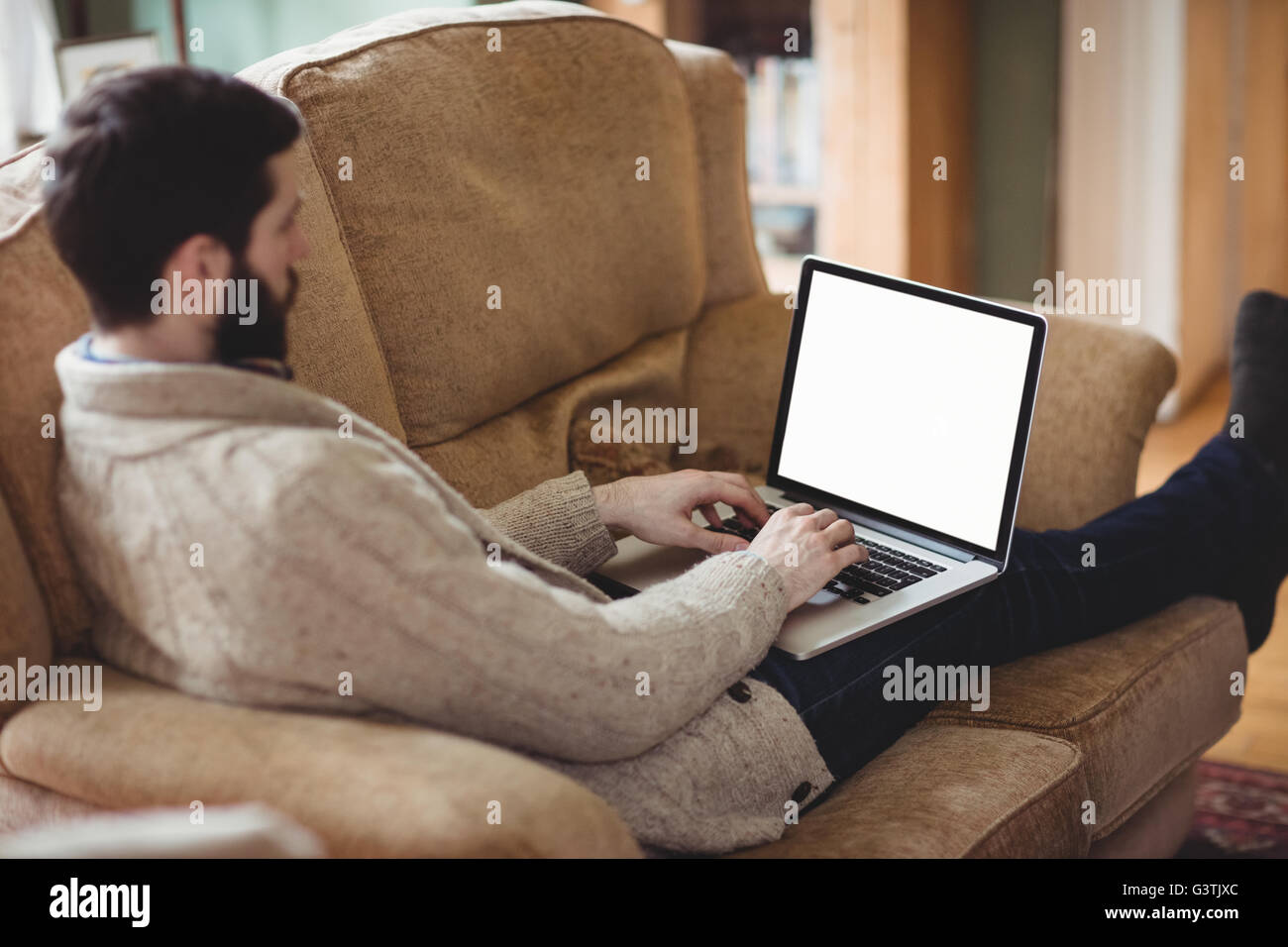 Close up view of hipster man using laptop in his sofa Stock Photo