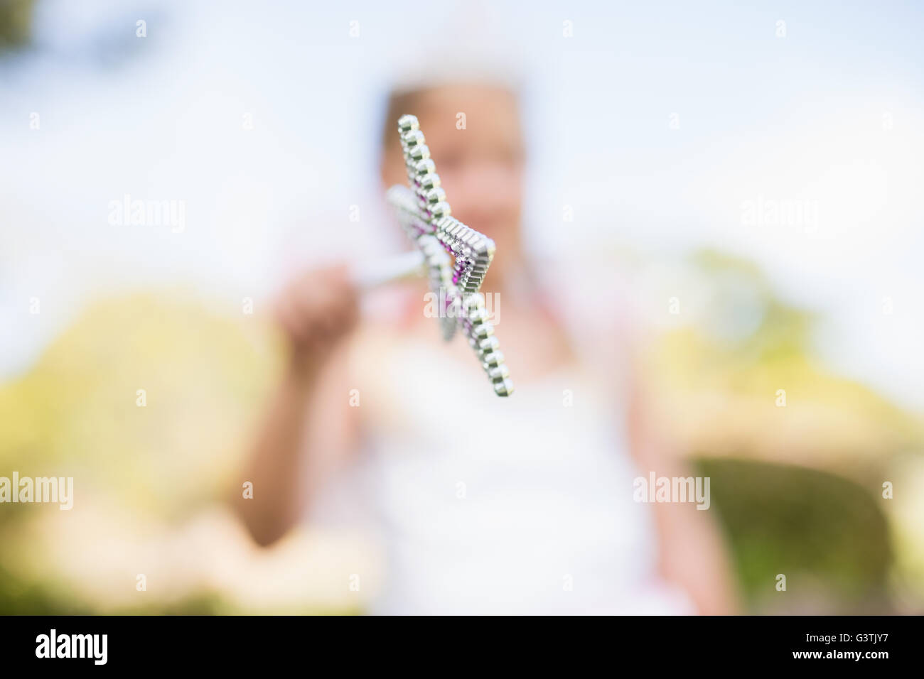 Blurred picture of girl pretending to be a fairy and pointing the camera with her magic wand Stock Photo
