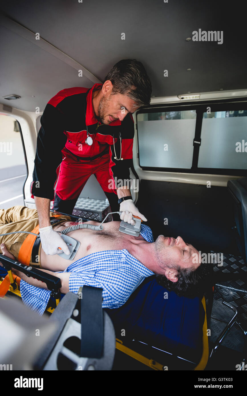 Ambulance man using defibrillator Stock Photo Alamy
