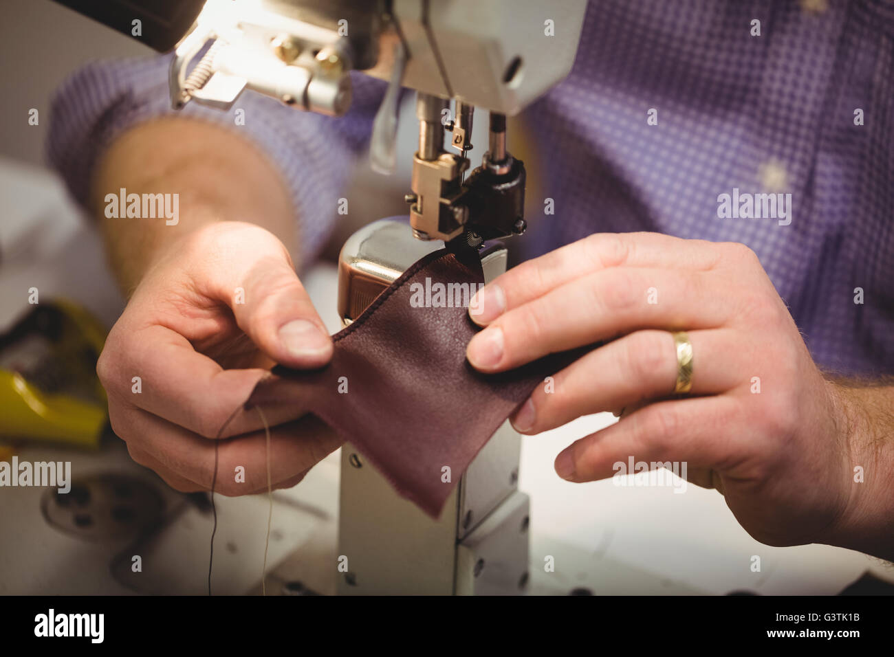Close up of hands sewing a piece of leather Stock Photo