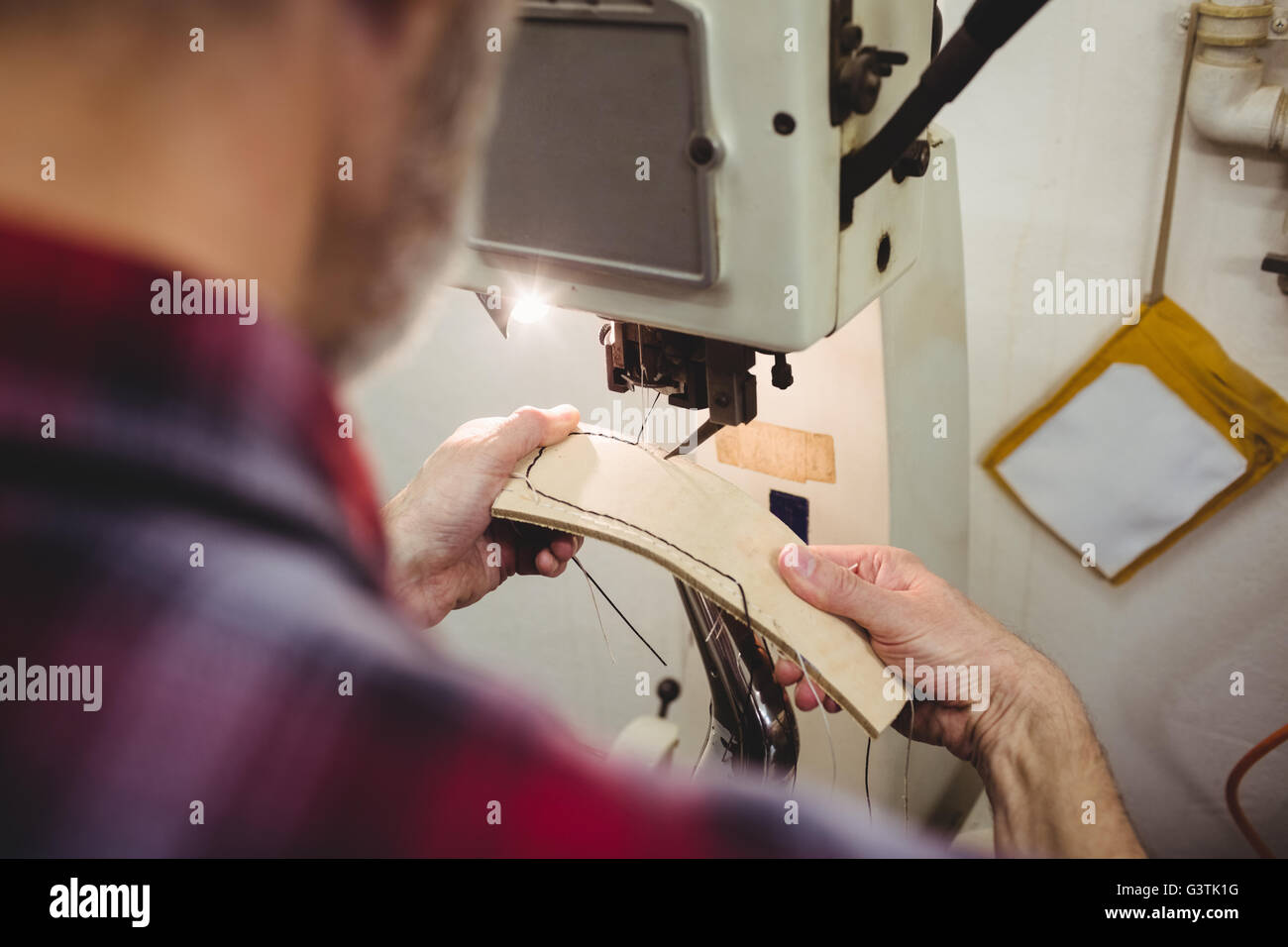 Rear view of cobbler using a sewing machine Stock Photo