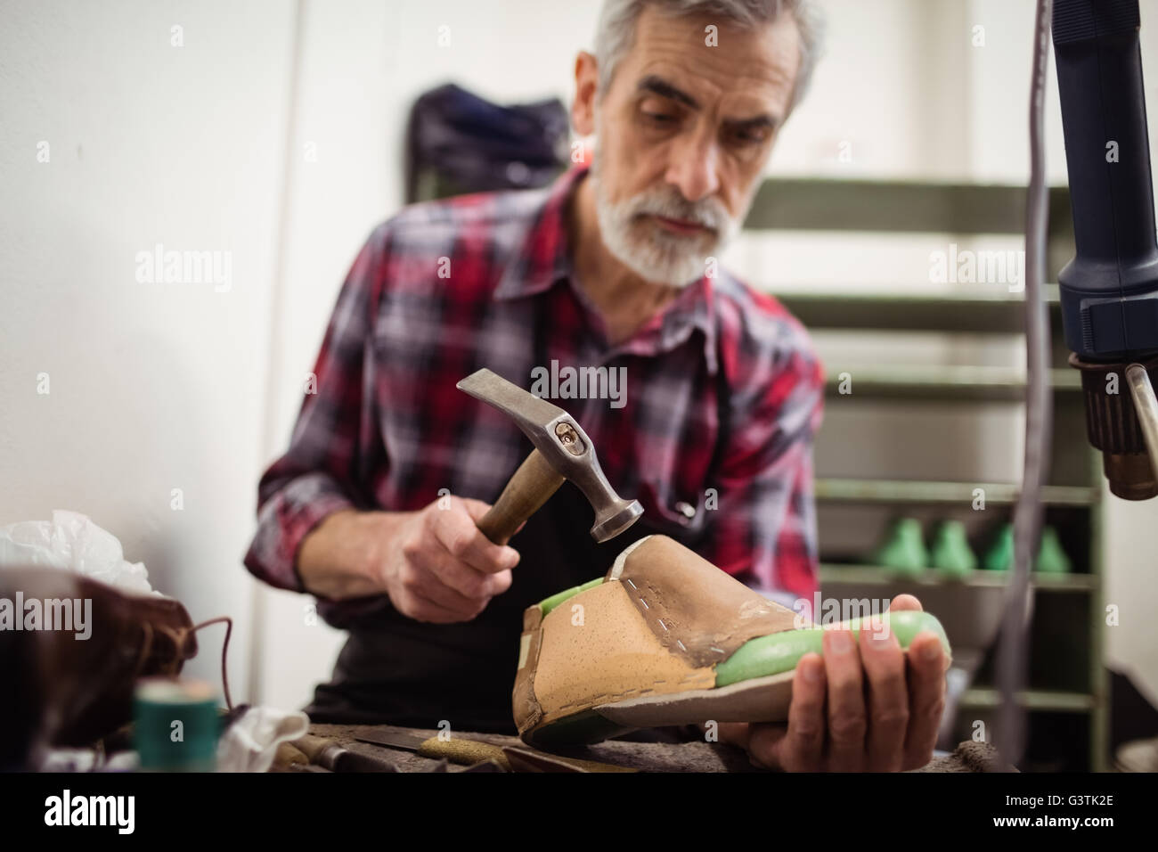 Low angle view of cobbler hammering on a shoe Stock Photo