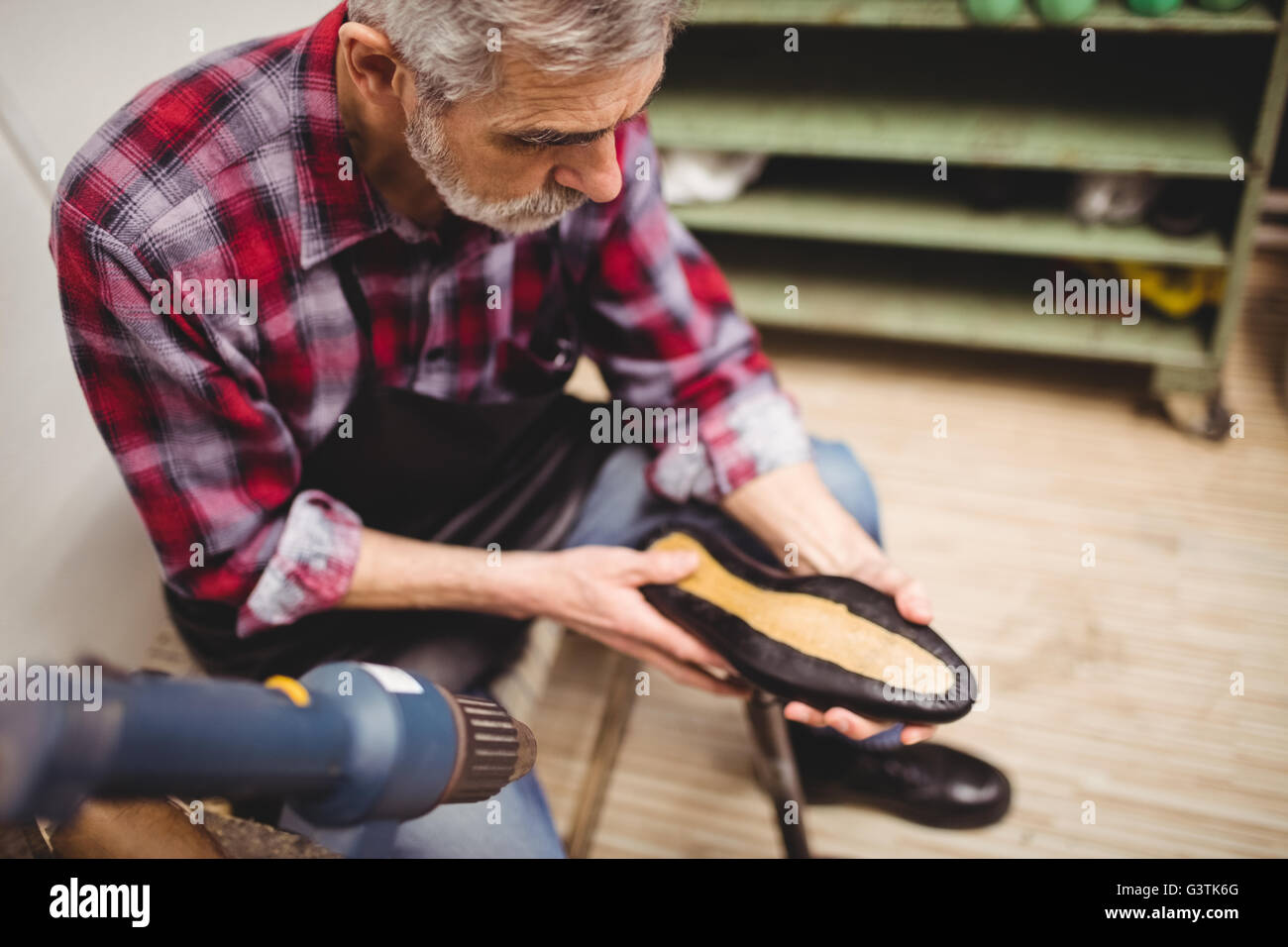 Overhead of cobbler checking a shoe Stock Photo