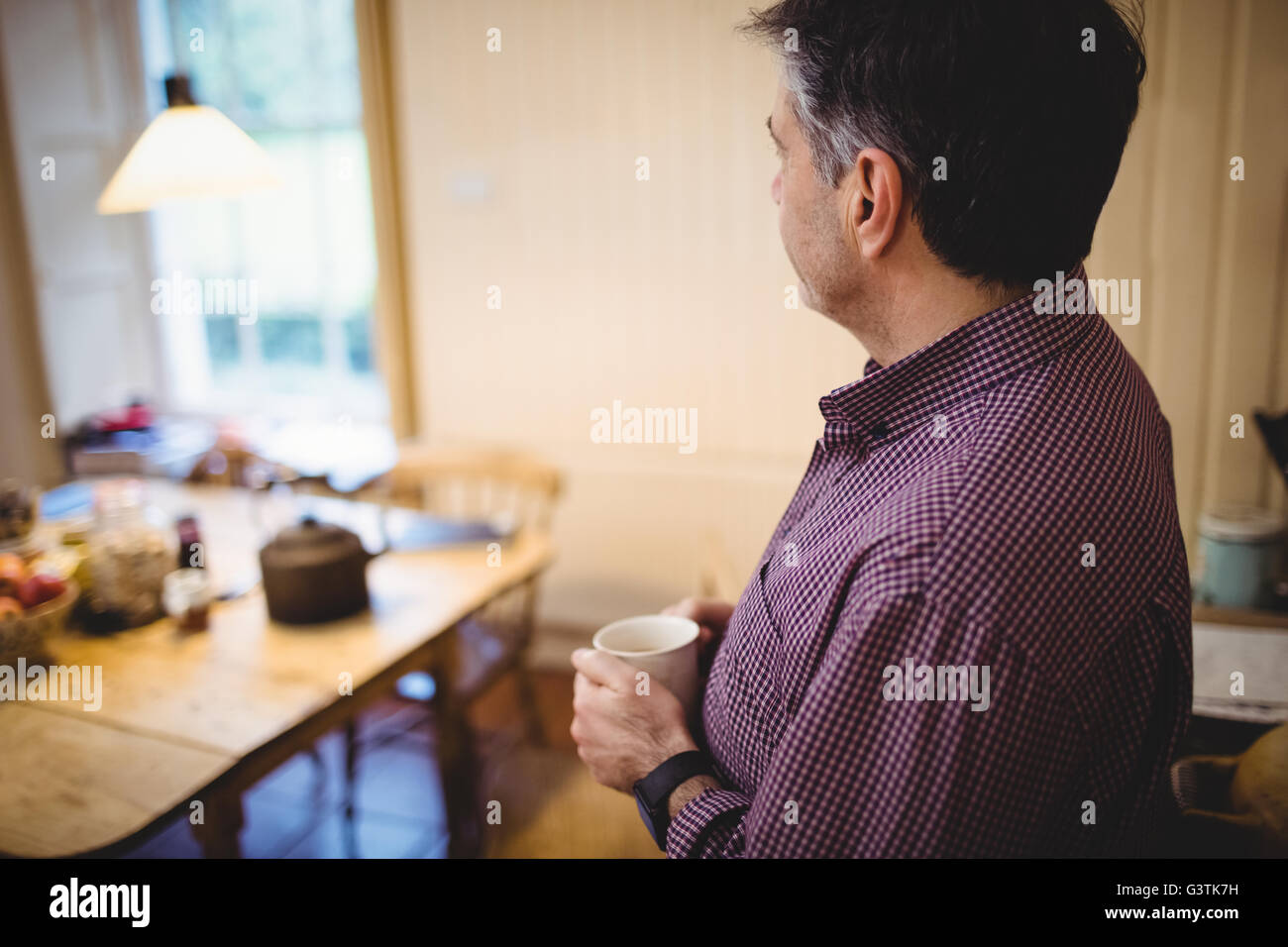 Profile view of mature man standing with cup of coffee Stock Photo