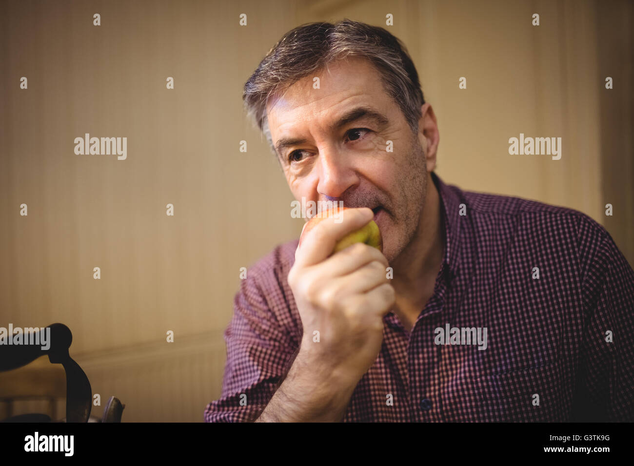 Mature man eating an apple Stock Photo