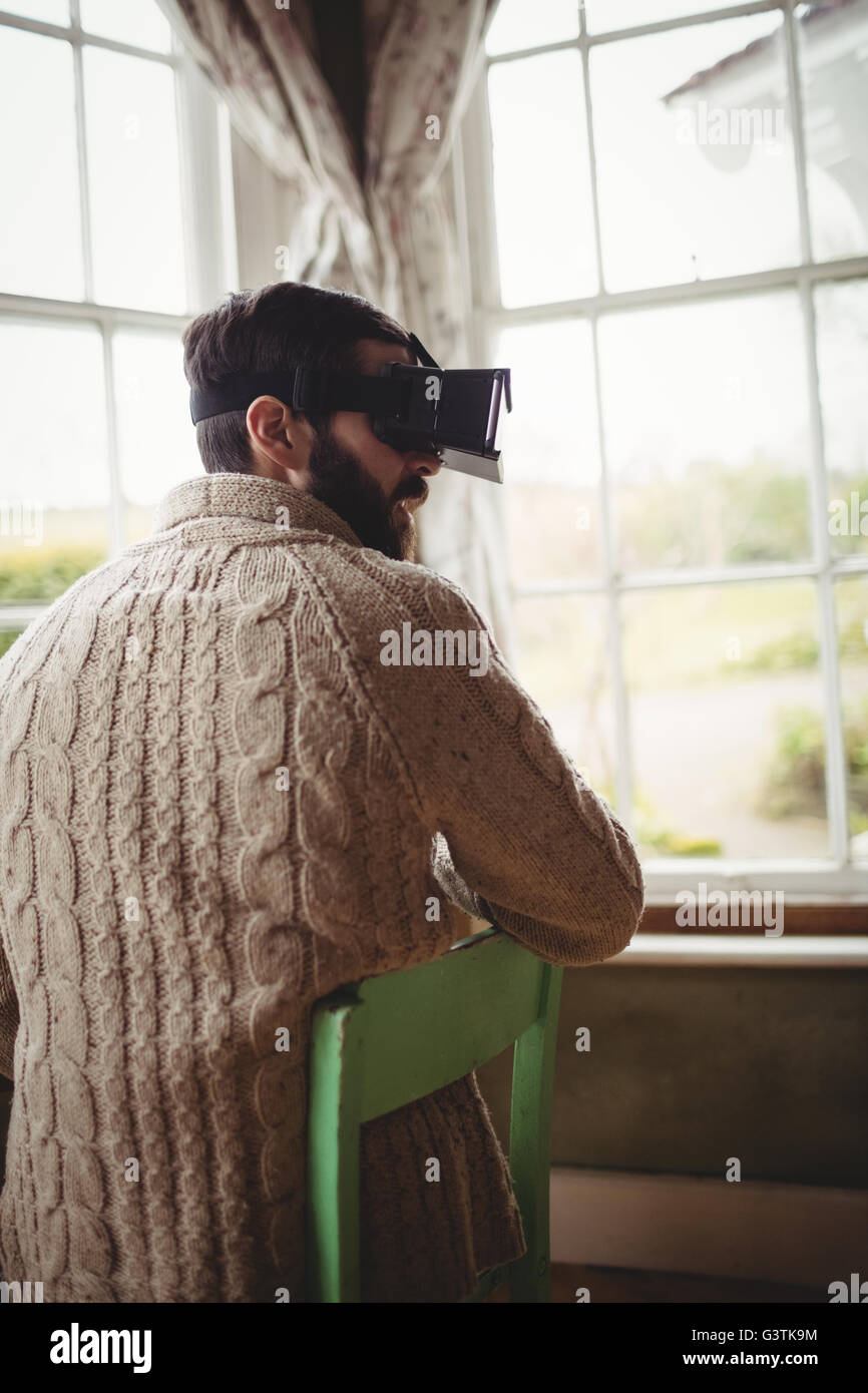 Profile view of hipster man using smart glasses while seating at desk Stock Photo