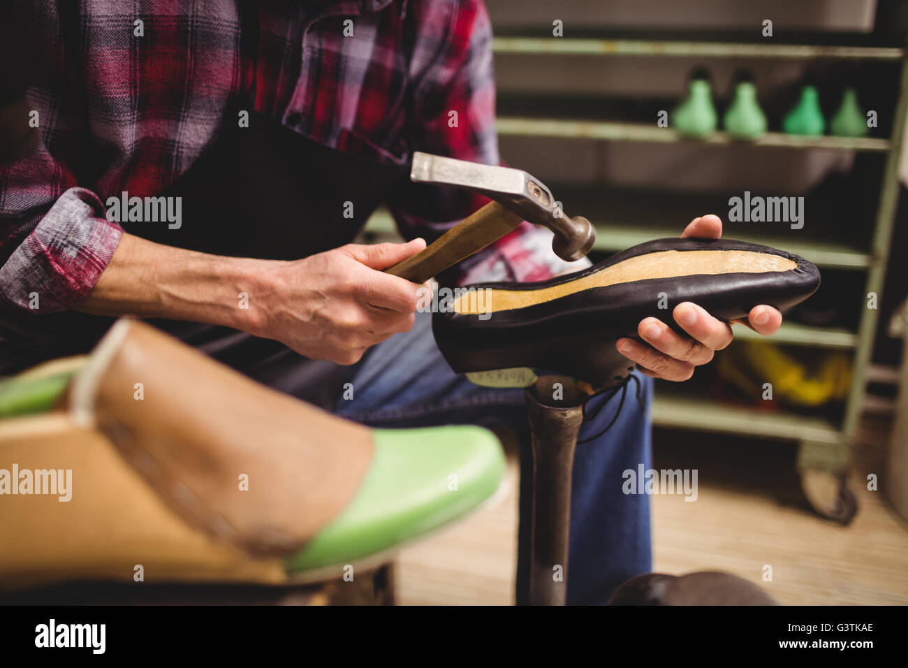 Close up of hand hammering on a shoe Stock Photo