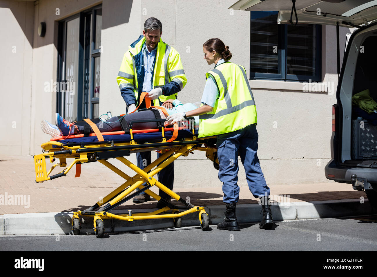 Ambulance men carrying injured people on stretcher Stock Photo