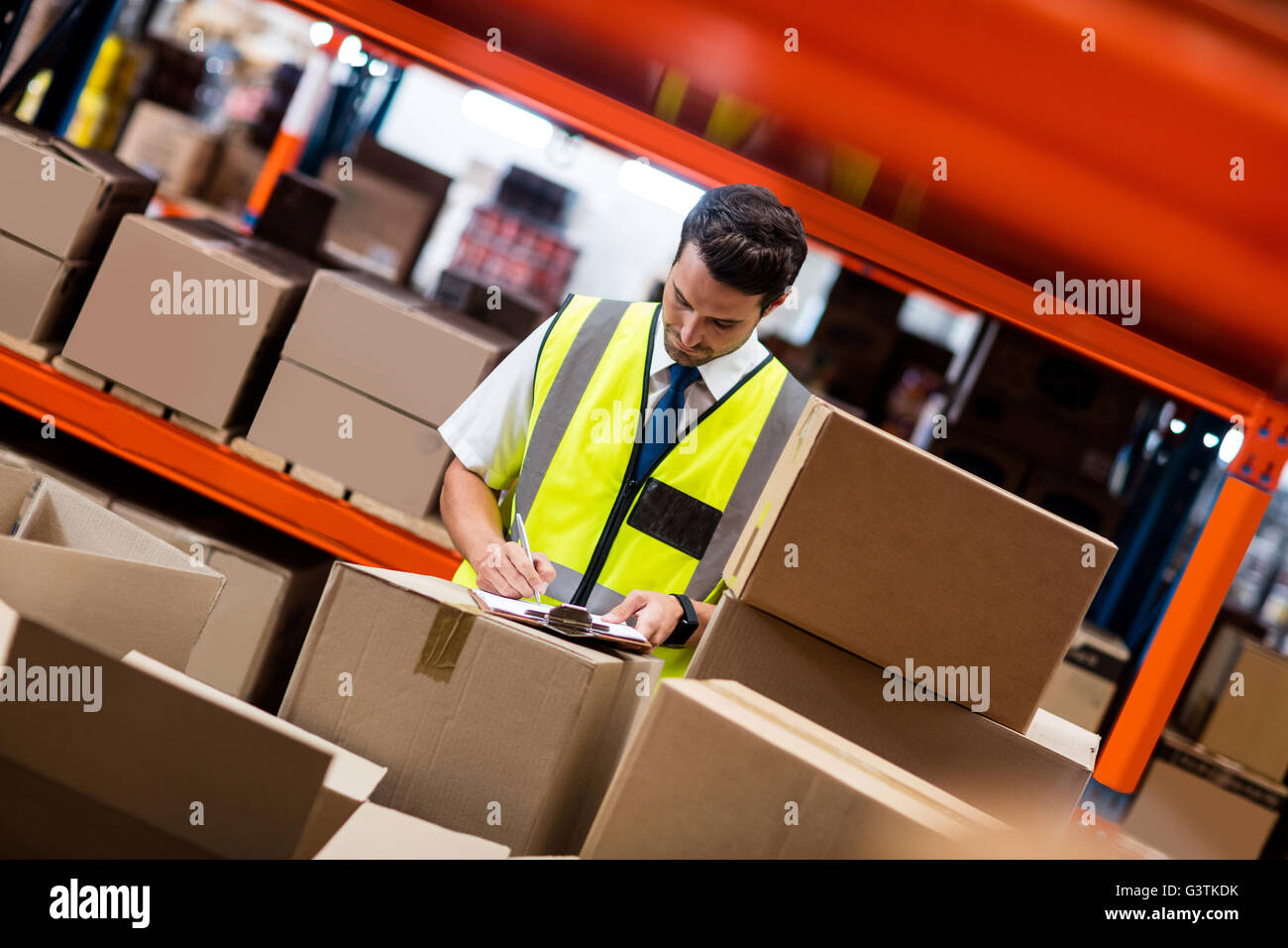 Warehouse manager writing on his clipboard Stock Photo - Alamy