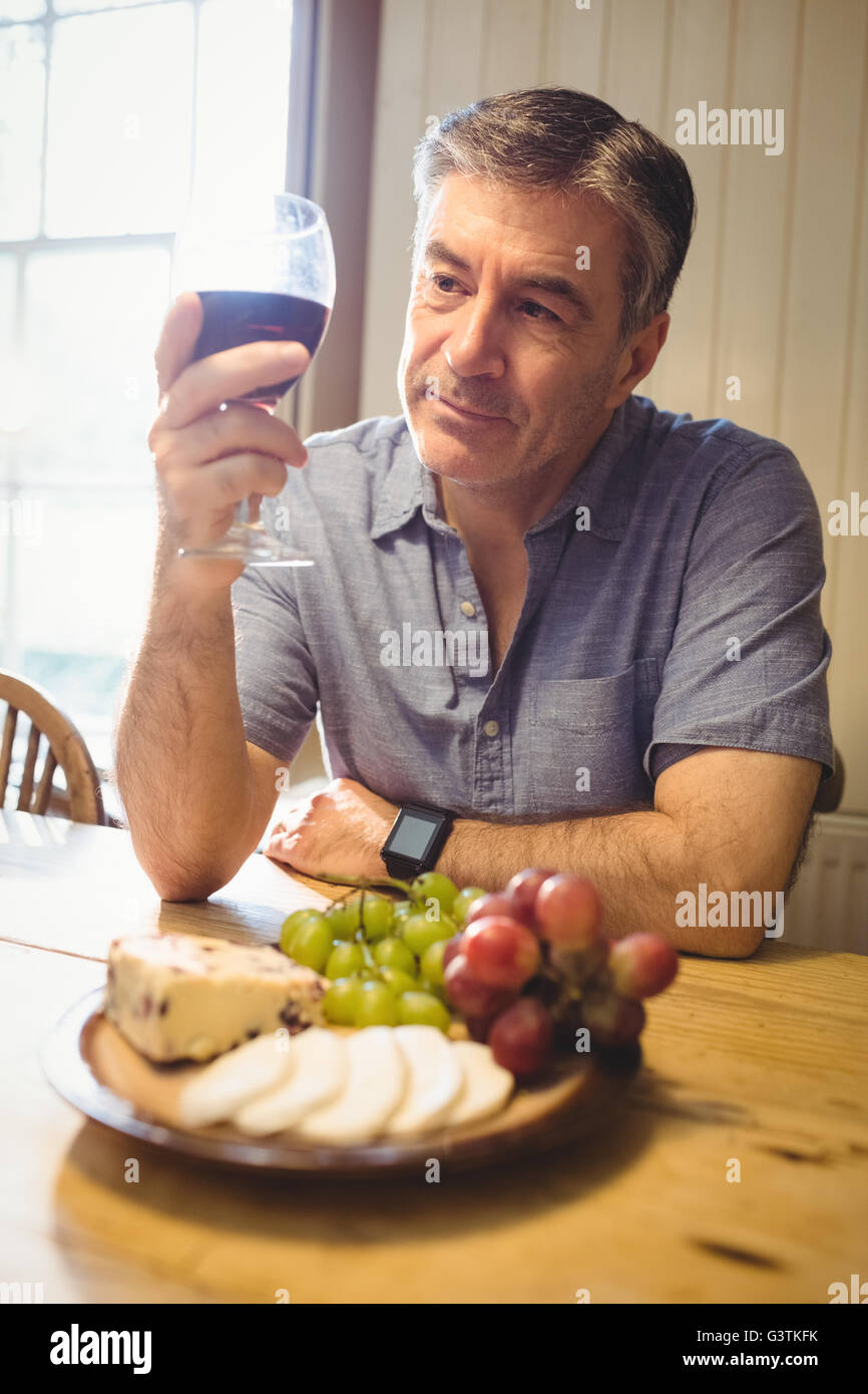 Mature man examining glass of wine Stock Photo