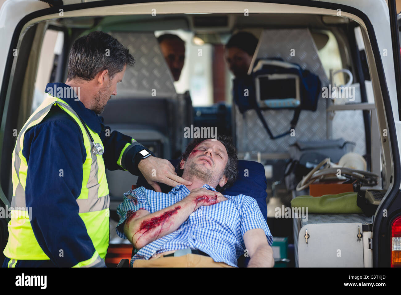 Injured man with ambulance men Stock Photo