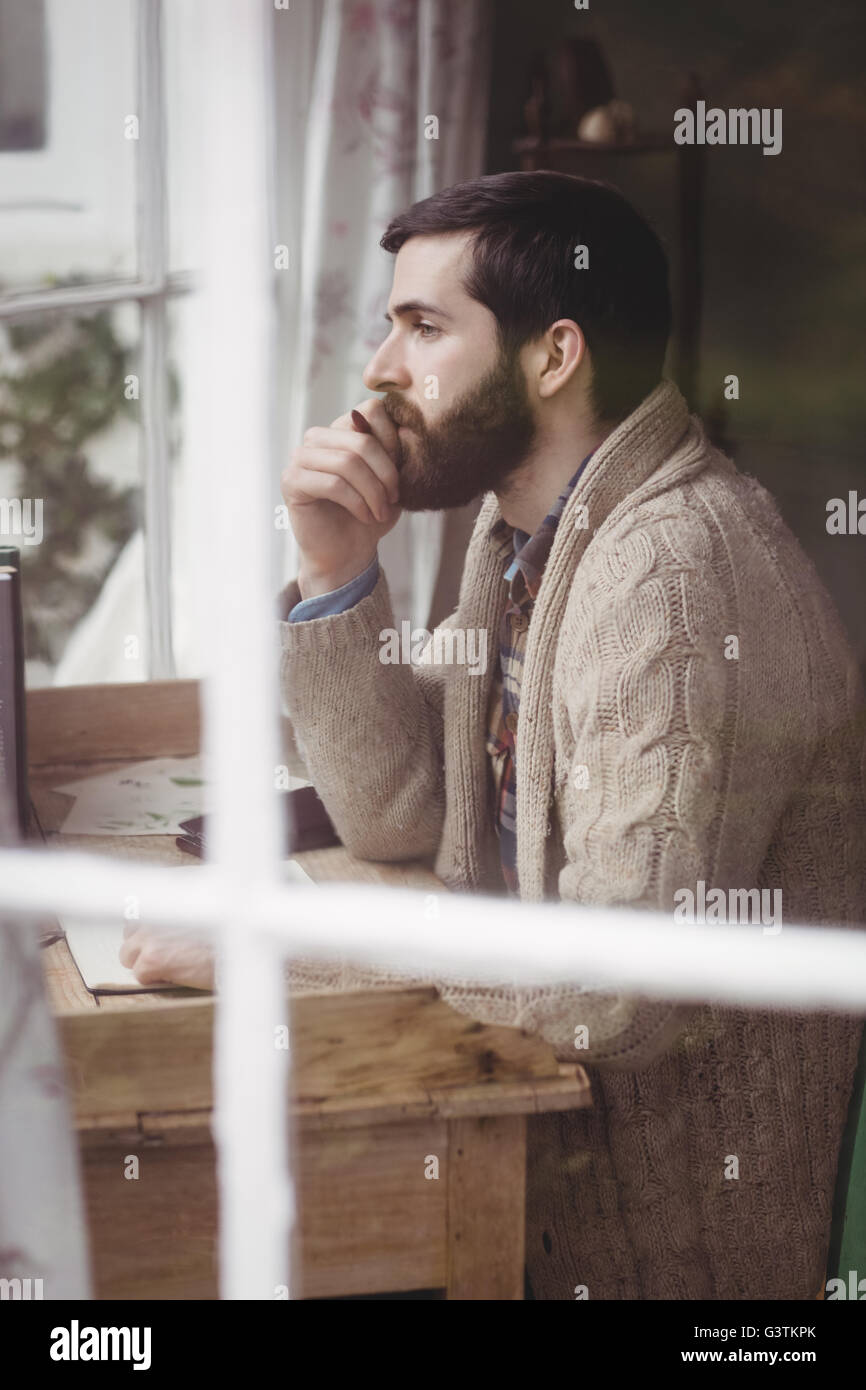 Profile view of attractive hipster man looking through window Stock Photo