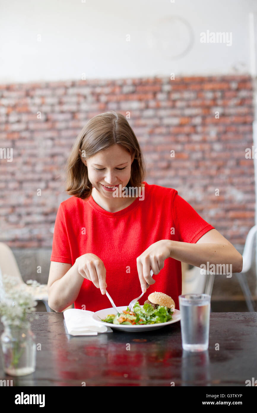 Finland, Smiling woman having lunch Stock Photo