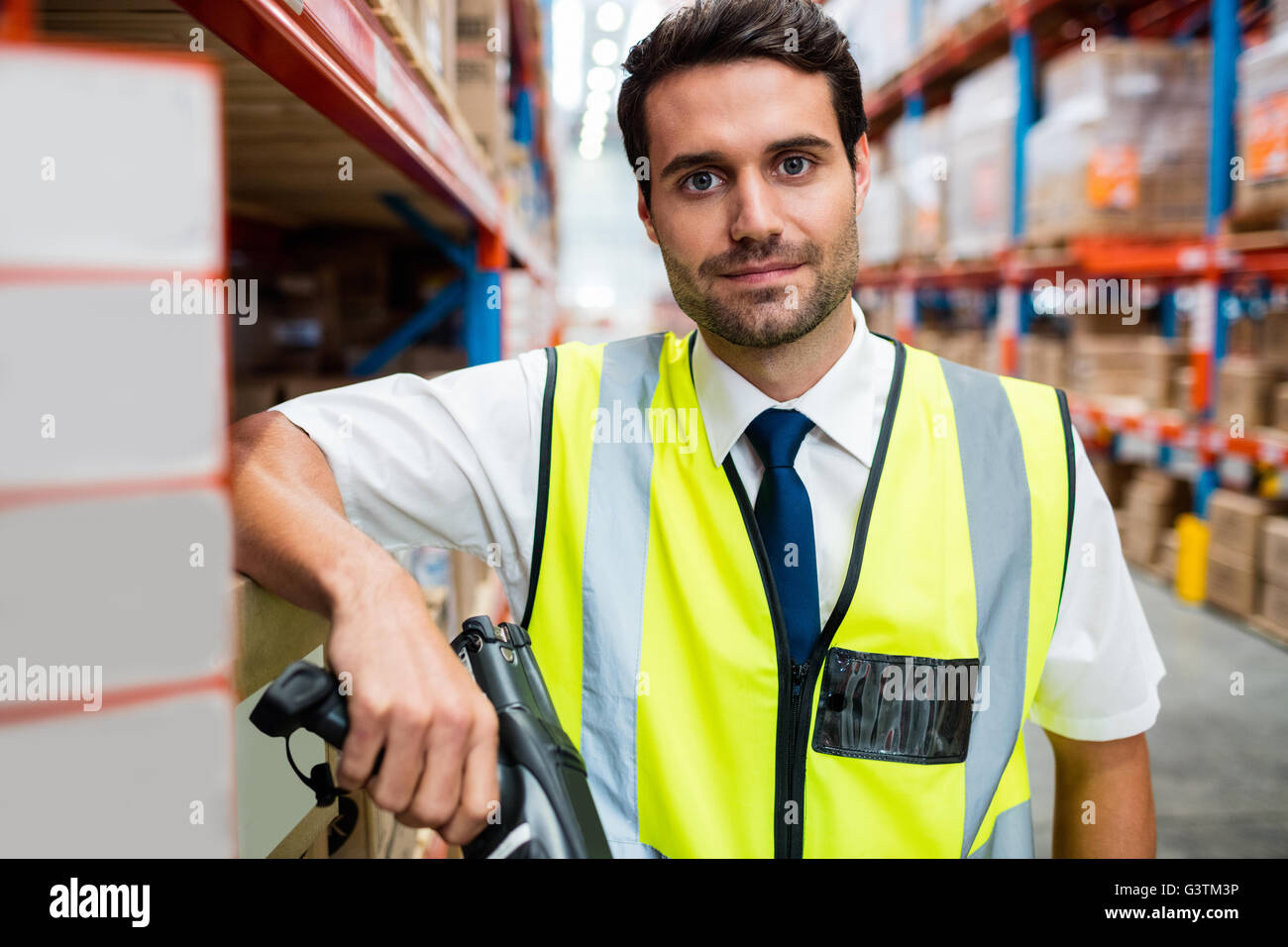 Warehouse manager with yellow coat and scanner in warehouse Stock Photo