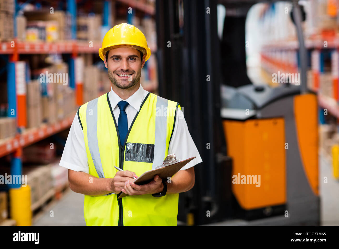 Smiling warehouse manager with clipboard Stock Photo