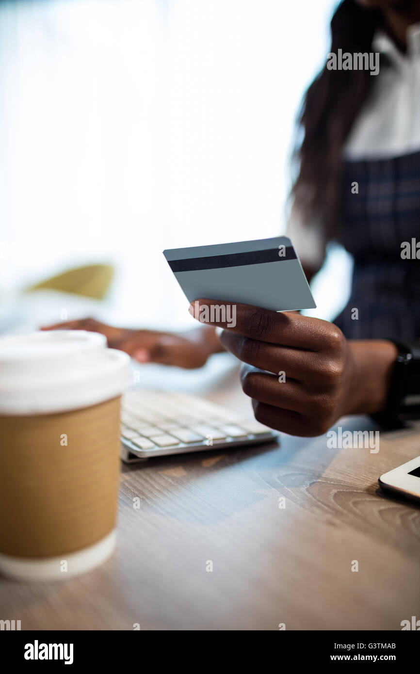 Business woman holding credit card and typing on the computer Stock Photo
