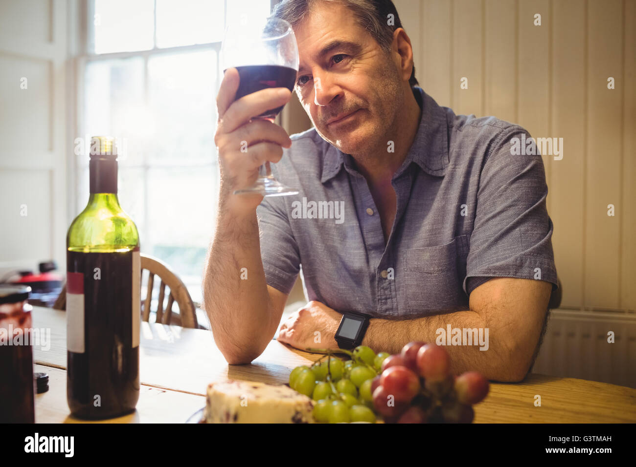 Mature man examining glass of wine Stock Photo