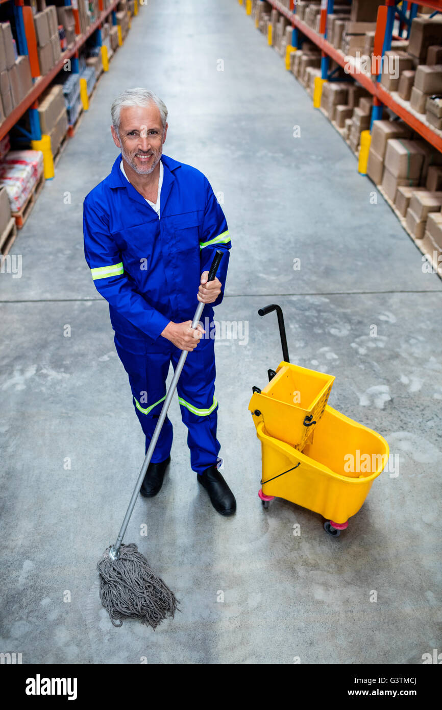 Smiling man moping warehouse floor Stock Photo Alamy