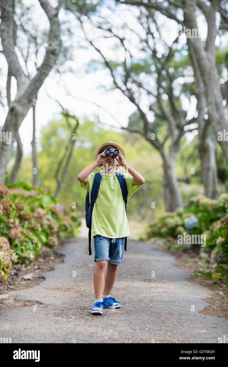 Young boy looking through binoculars in park Stock Photo