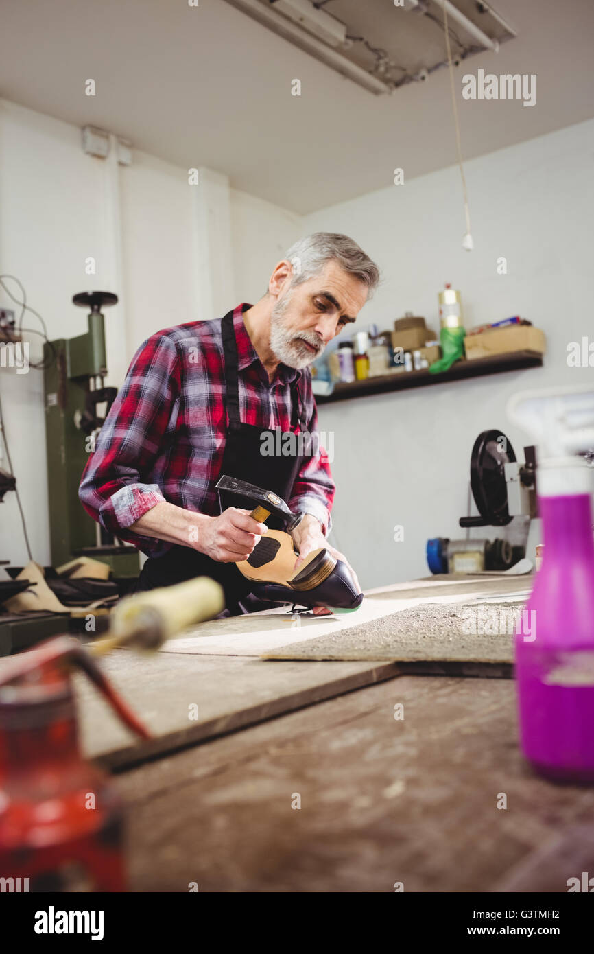 Cobbler hammering on the heel of a shoe Stock Photo