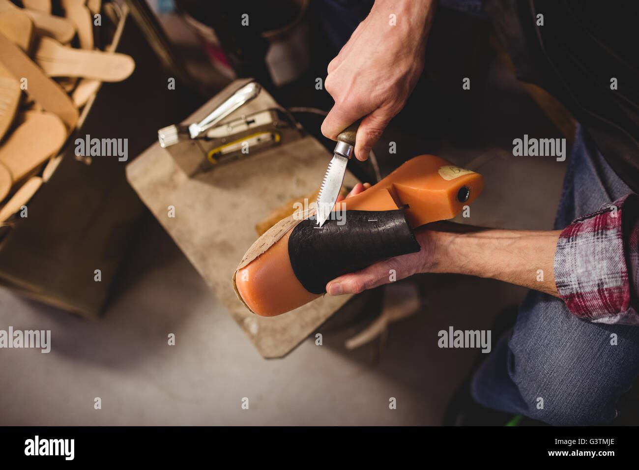 Overhead of cobbler using a knife on a shoe Stock Photo