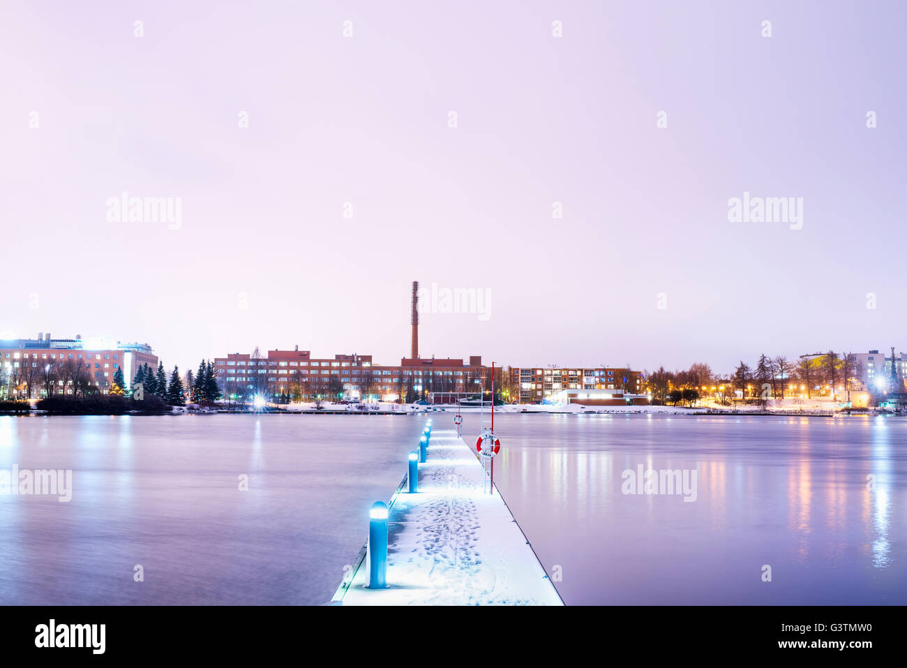 Finland, Pirkanmaa, Tampere, Pyhajarvi, Illuminated pier over lake at dusk Stock Photo