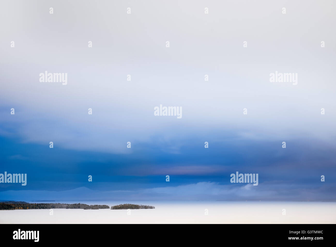 Finland, Pirkanmaa, Tampere, Nasijarvi, Frozen lake under cloudy sky at dusk Stock Photo