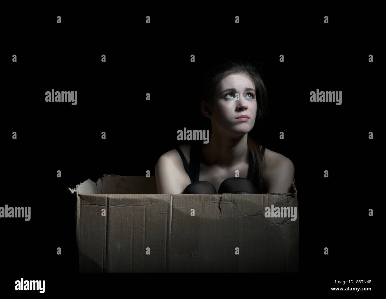 Upset girl posing sitting in cardboard box Stock Photo - Alamy