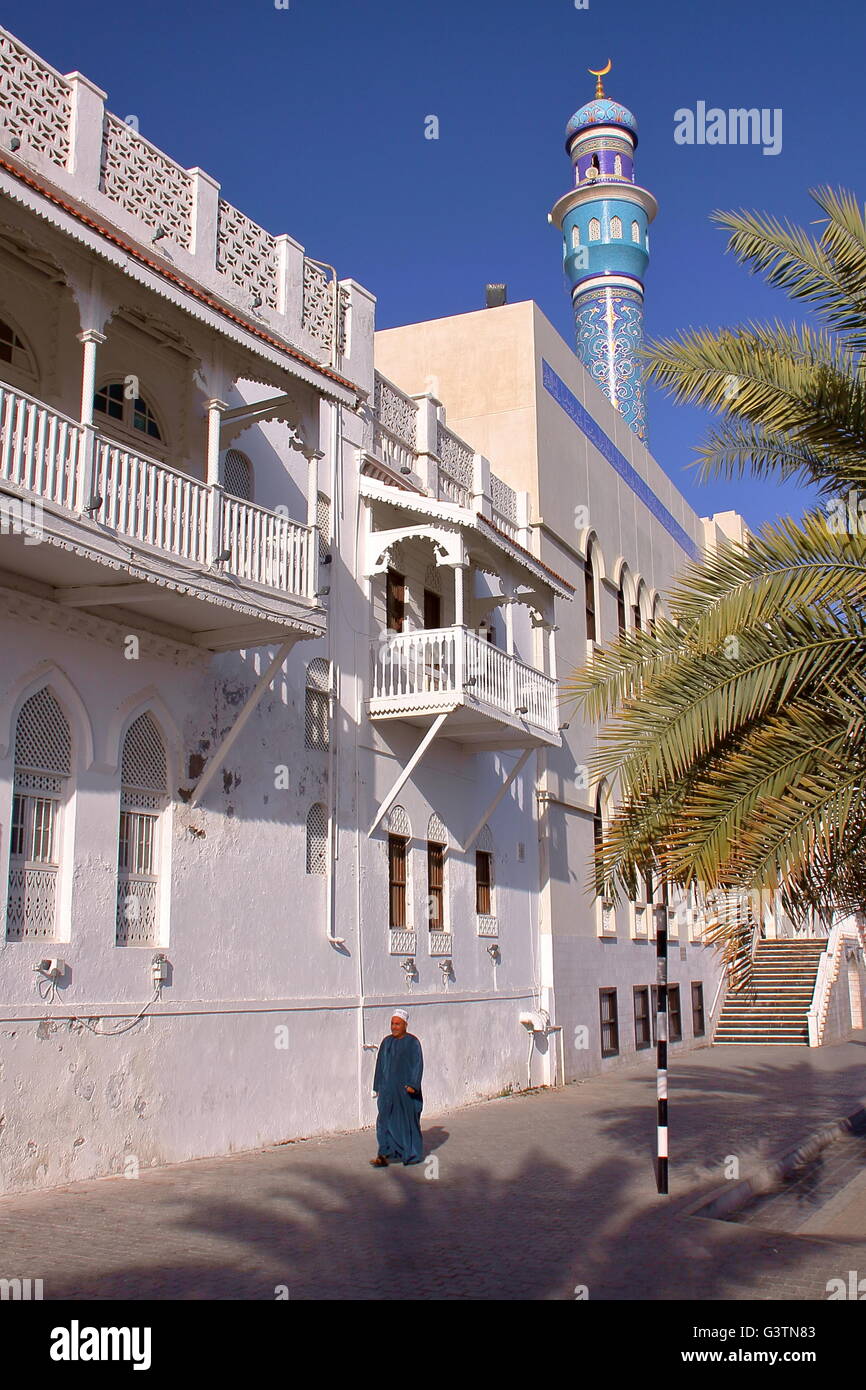 An Omani man walking in front of Sur Al Lewatia Mosque in Muttrah, Muscat, Oman Stock Photo