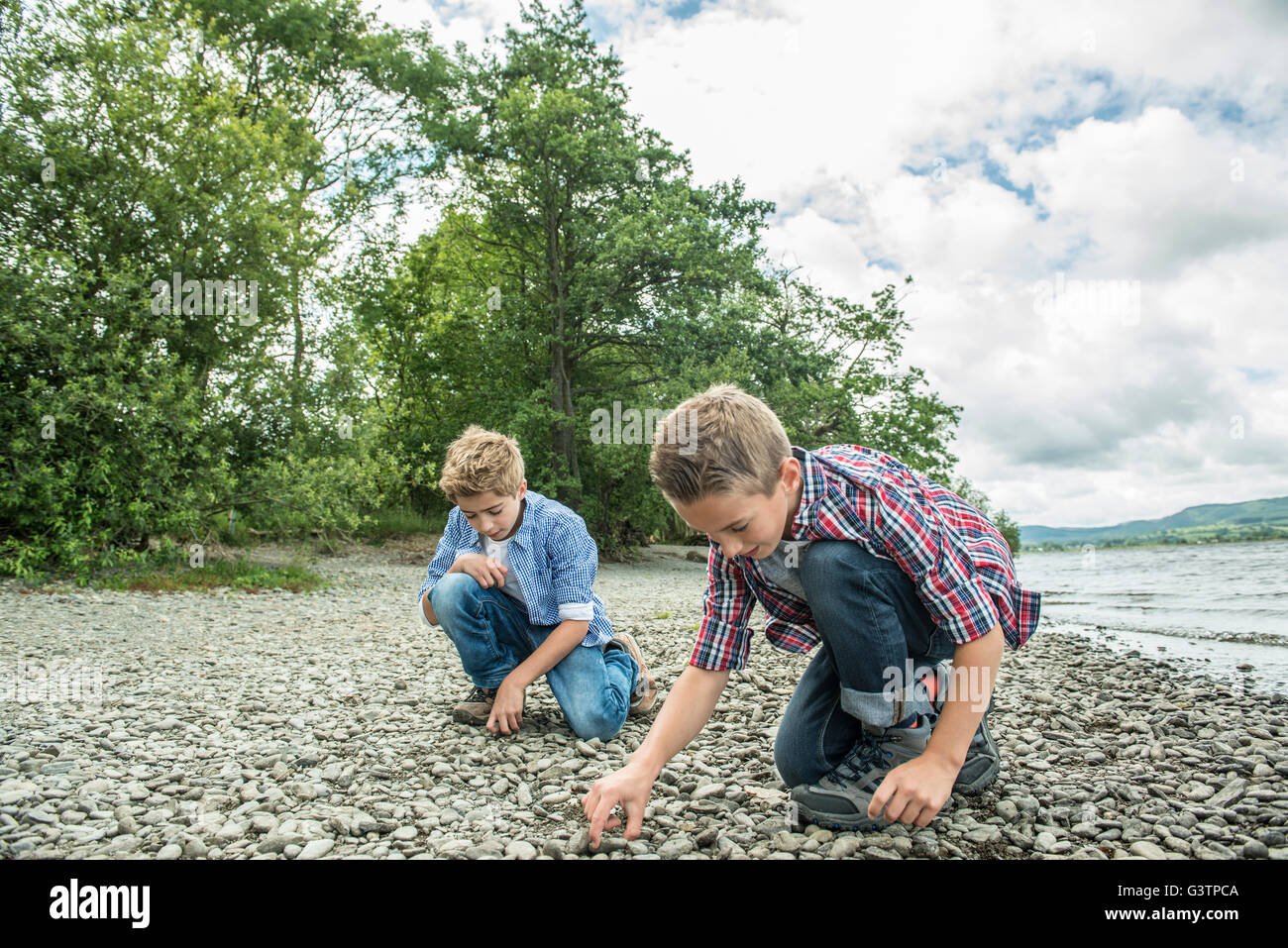Two boys playing on the shore beside Bala Lake in Wales. Stock Photo