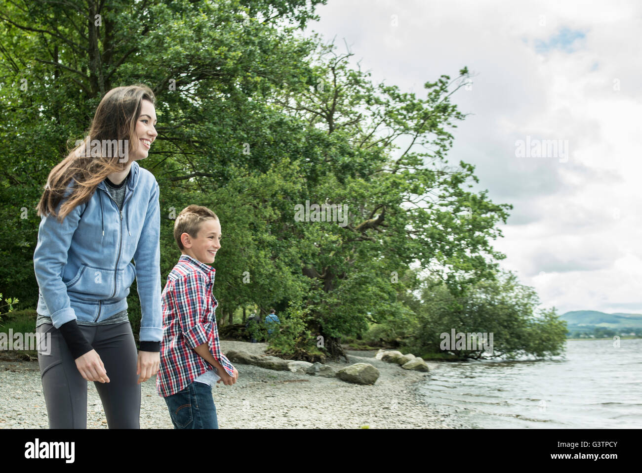 A girl and a boy playing on the shore beside Bala Lake in Wales. Stock Photo