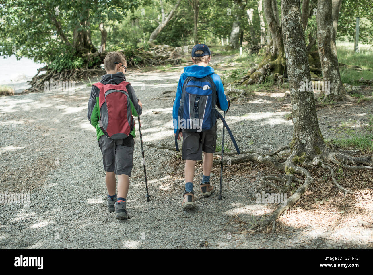 Two boys in hiking clothing walking on the shore beside Bala Lake in Wales Stock Photo Alamy
