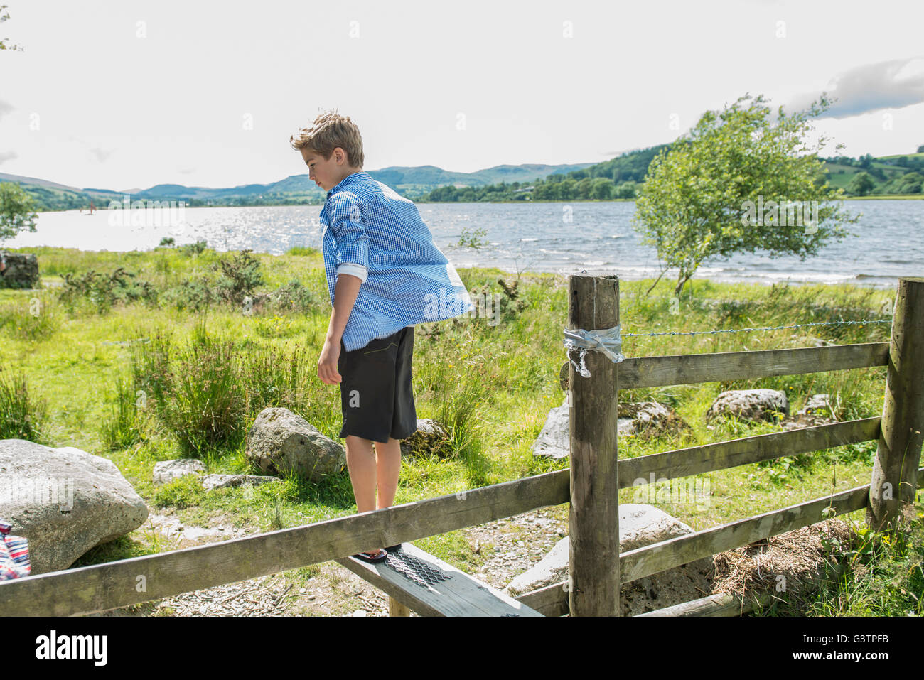 A boy standing on a stile beside Bala Lake in Wales. Stock Photo