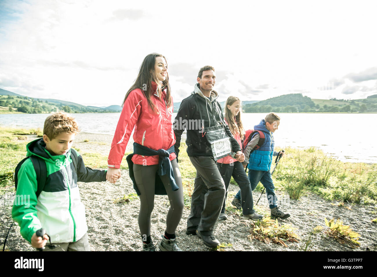 A family of five walking on the shore of Bala Lake in Wales. Stock Photo