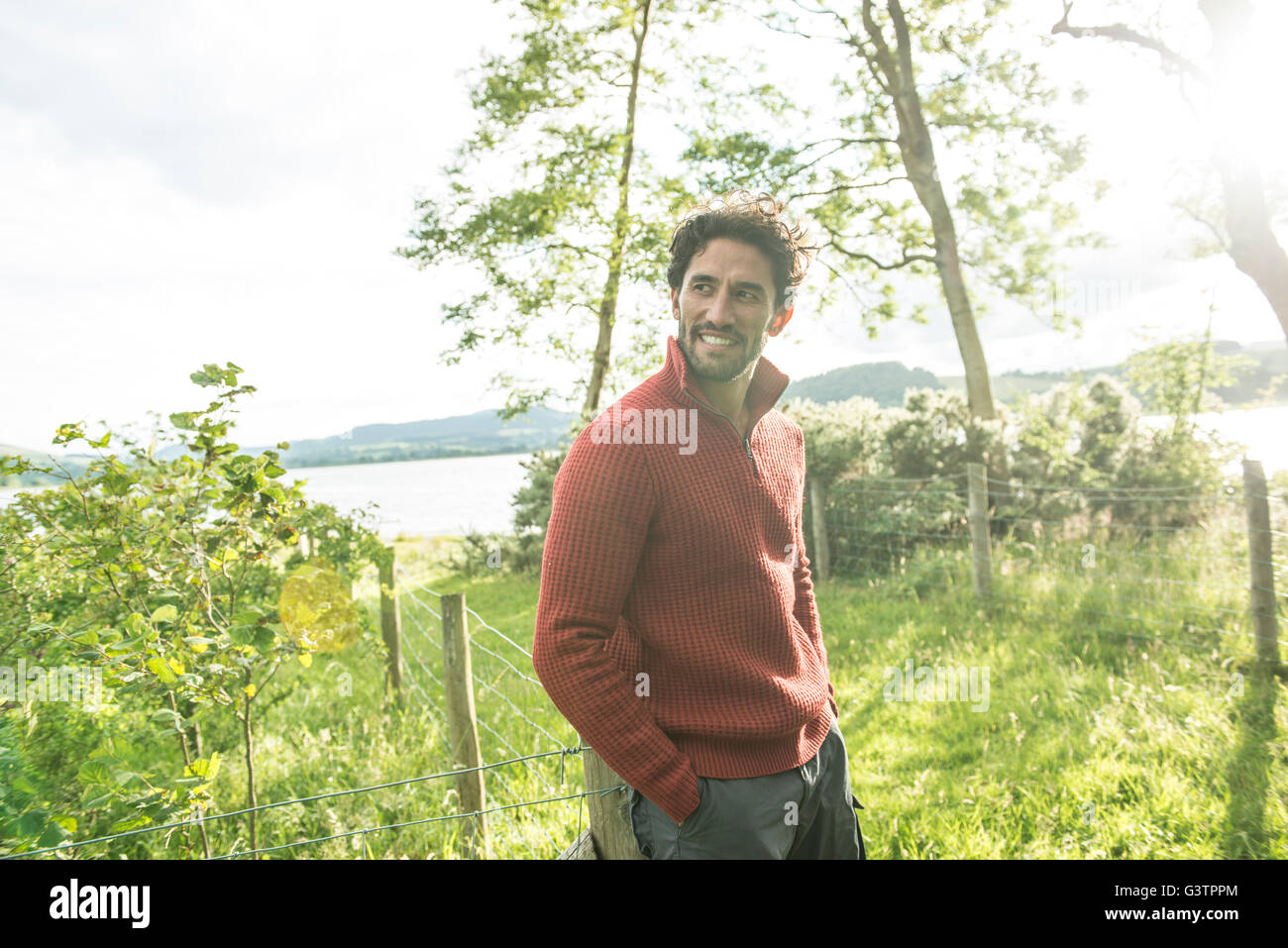 A bearded man in a red jumper standing on the shore of Bala Lake in Wales. Stock Photo